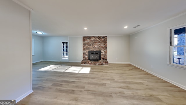 unfurnished living room with ornamental molding, light wood-type flooring, and baseboards