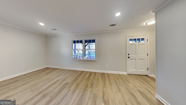 entryway featuring ornamental molding, light wood-type flooring, visible vents, and baseboards