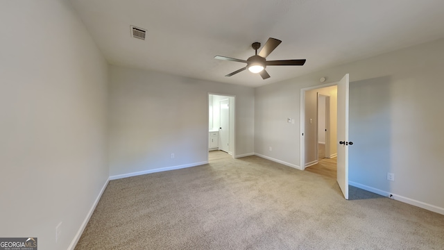 unfurnished bedroom featuring visible vents, baseboards, a ceiling fan, ensuite bathroom, and carpet flooring