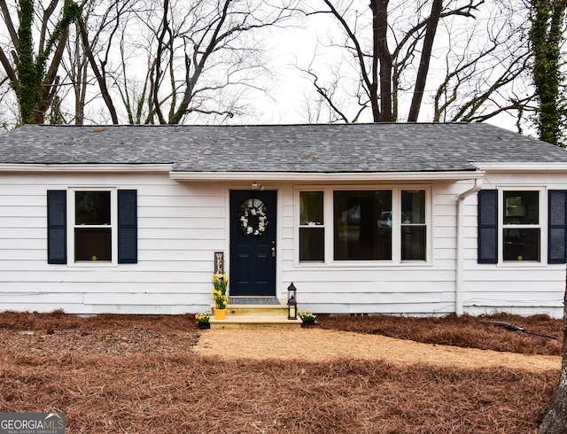 ranch-style home with roof with shingles