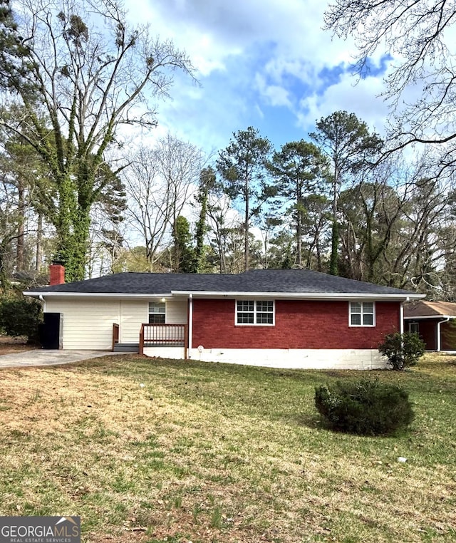 view of front of property with brick siding, a chimney, and a front lawn