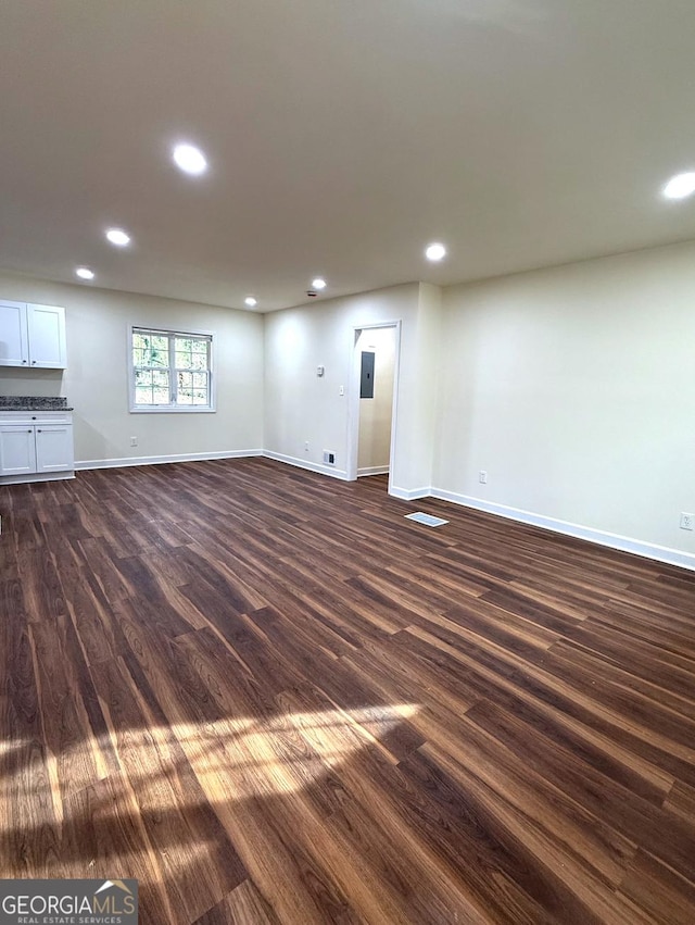 unfurnished room with dark wood-style floors, recessed lighting, and baseboards