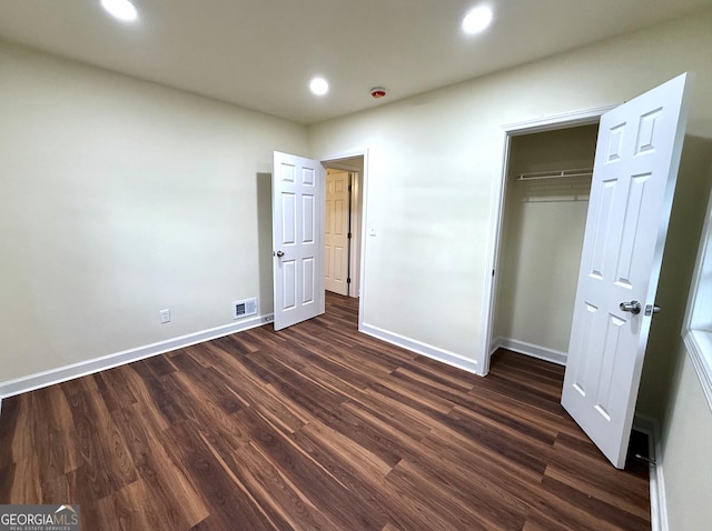 unfurnished bedroom with a closet, baseboards, dark wood-style flooring, and recessed lighting