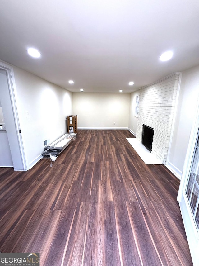 basement featuring recessed lighting, a fireplace, wood finished floors, and baseboards