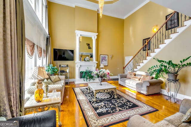 living room with baseboards, stairway, a high ceiling, and wood finished floors