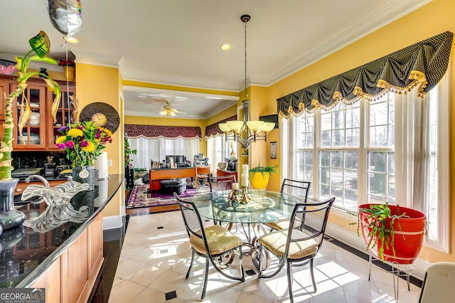 dining space with light tile patterned floors, ceiling fan with notable chandelier, and crown molding