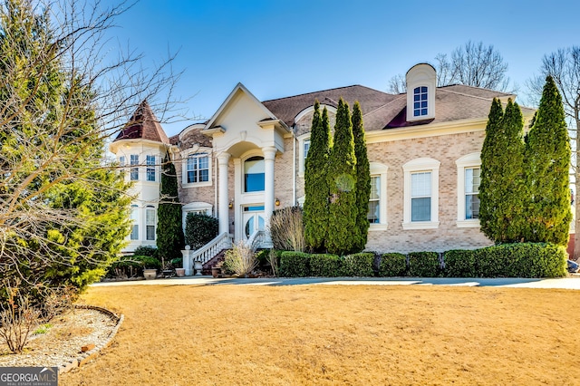 view of front facade featuring a front yard and brick siding