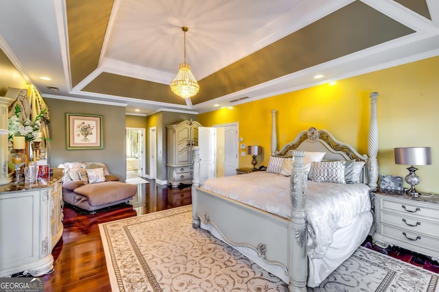 bedroom with visible vents, connected bathroom, dark wood-style flooring, a tray ceiling, and crown molding