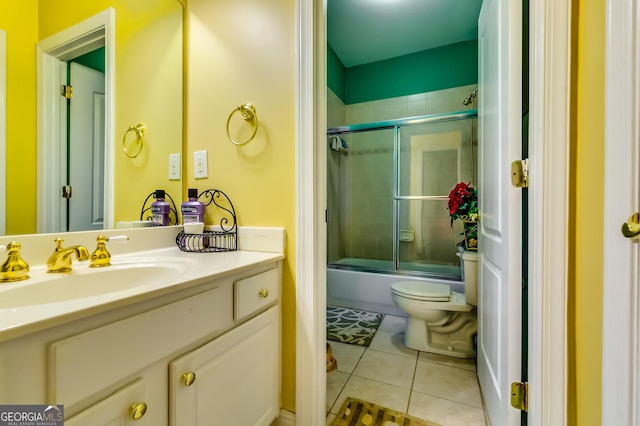 full bathroom with toilet, tile patterned flooring, combined bath / shower with glass door, and vanity