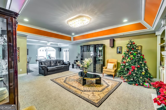 carpeted living room with baseboards, recessed lighting, a raised ceiling, and crown molding