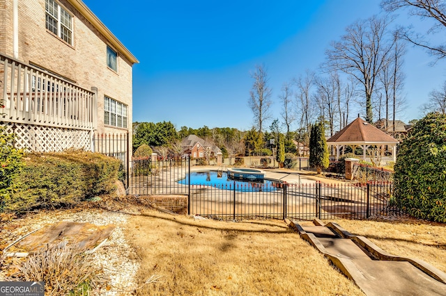 view of pool with a patio, a gazebo, fence, and a pool with connected hot tub