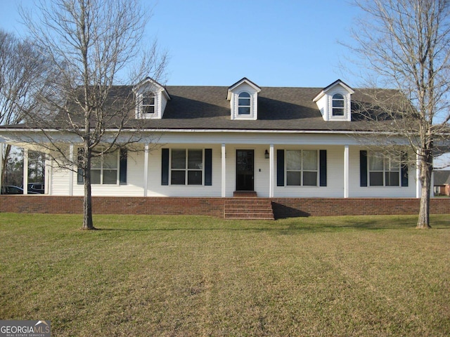 view of front of property featuring a porch, roof with shingles, a front yard, and brick siding