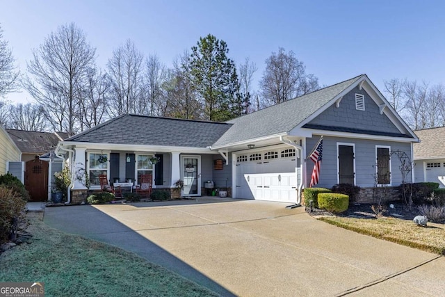 view of front of house with a garage, driveway, roof with shingles, and covered porch