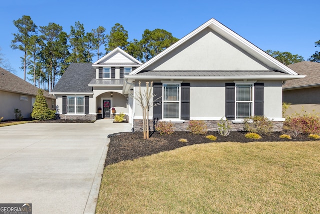 view of front of house with a front yard, a standing seam roof, metal roof, and stucco siding