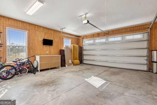 garage with wood walls and a garage door opener