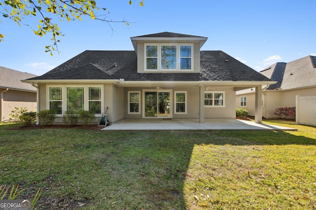 rear view of property featuring a patio area, a yard, and stucco siding