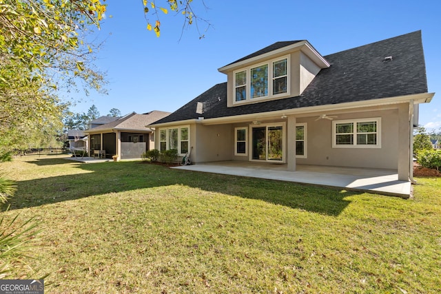 back of property featuring roof with shingles, a lawn, a patio area, and stucco siding