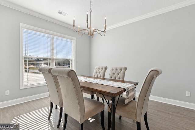 dining room with baseboards, crown molding, and wood finished floors