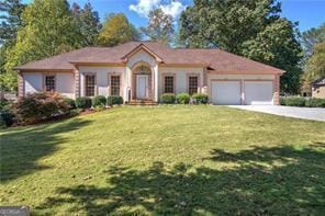 view of front of house with an attached garage, a front lawn, and concrete driveway