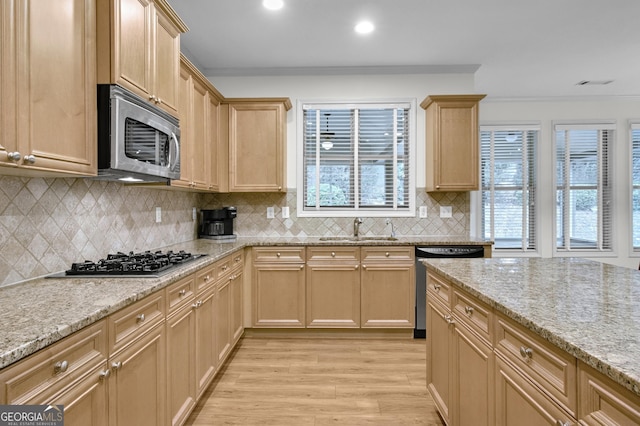 kitchen with light wood-style flooring, ornamental molding, stainless steel appliances, light brown cabinetry, and a sink