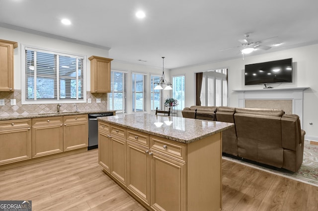 kitchen featuring crown molding, dishwasher, light wood-style flooring, and a sink