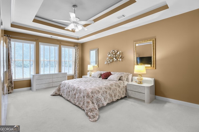 bedroom featuring ornamental molding, a tray ceiling, visible vents, and carpet