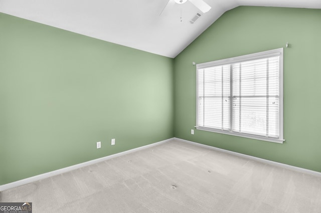 carpeted empty room featuring vaulted ceiling, ceiling fan, visible vents, and baseboards