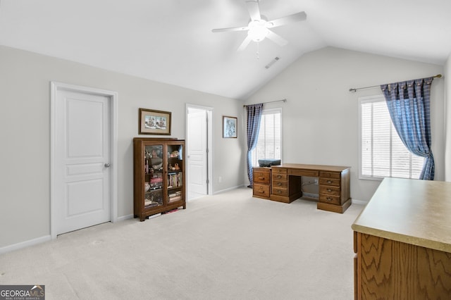 office with a healthy amount of sunlight, light carpet, and vaulted ceiling