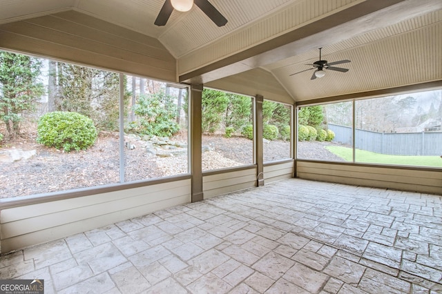 unfurnished sunroom with ceiling fan, vaulted ceiling, and a wealth of natural light