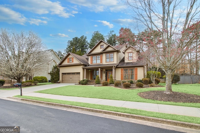 view of front of house with an attached garage, concrete driveway, a front yard, and fence