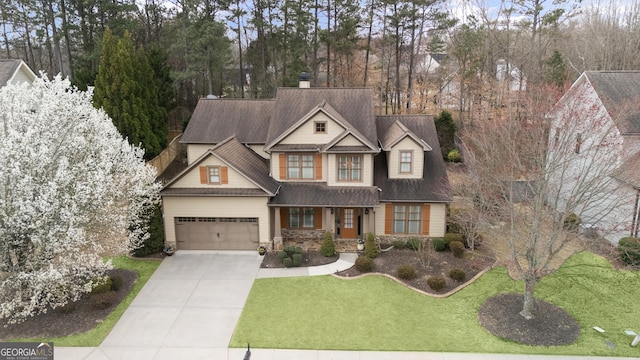 view of front facade featuring a shingled roof, a garage, stone siding, driveway, and a front lawn