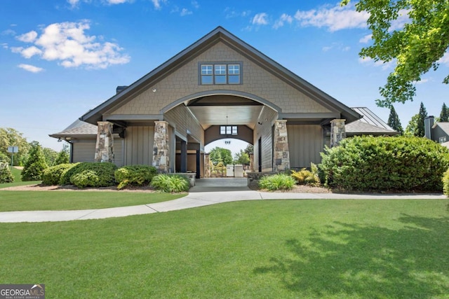 craftsman-style house featuring stone siding, board and batten siding, and a front yard