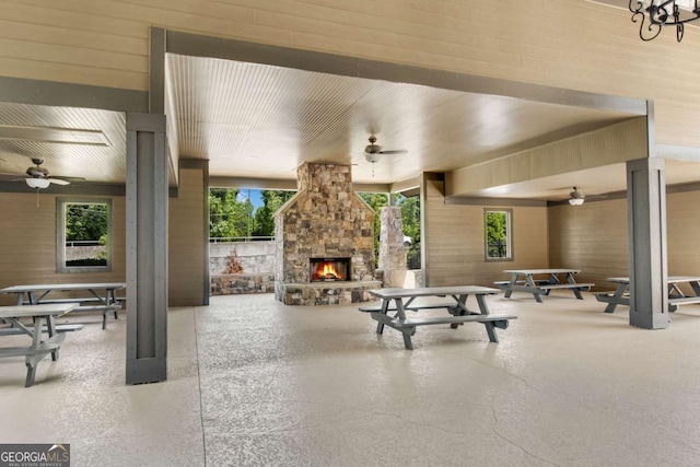 view of patio featuring an outdoor stone fireplace and a ceiling fan