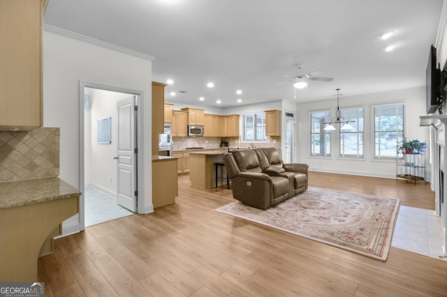 living area with recessed lighting, crown molding, light wood finished floors, and ceiling fan with notable chandelier