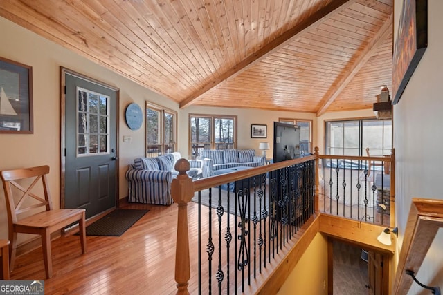 interior space with vaulted ceiling with beams, wooden ceiling, wood finished floors, and an upstairs landing