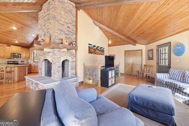 living room with beam ceiling, a fireplace, light wood finished floors, high vaulted ceiling, and wooden ceiling