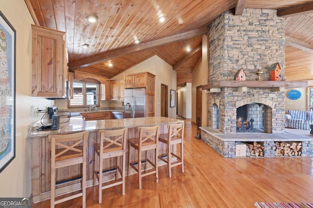 kitchen featuring wooden ceiling, stainless steel appliances, a fireplace, a sink, and light wood-type flooring