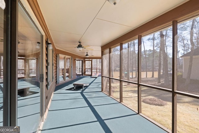 unfurnished sunroom featuring ceiling fan