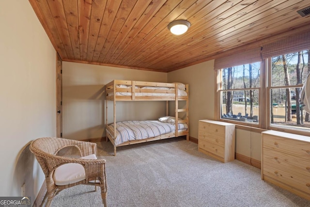 bedroom with wood ceiling, light carpet, and baseboards