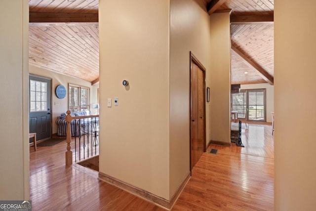 hall with plenty of natural light, wooden ceiling, wood-type flooring, and beam ceiling