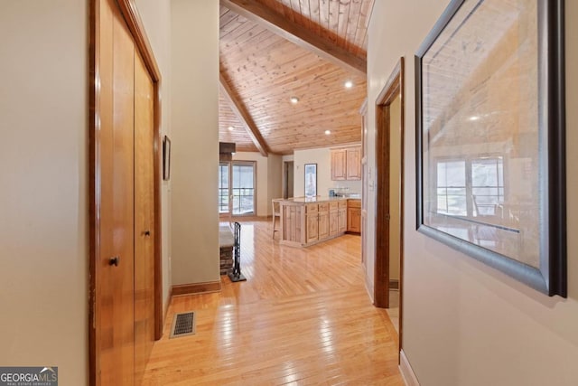 hallway with lofted ceiling with beams, light wood-style flooring, visible vents, wood ceiling, and baseboards