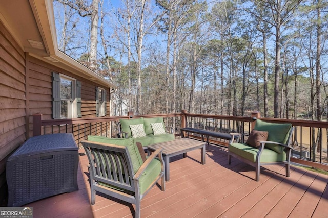 wooden terrace with a wooded view and an outdoor hangout area