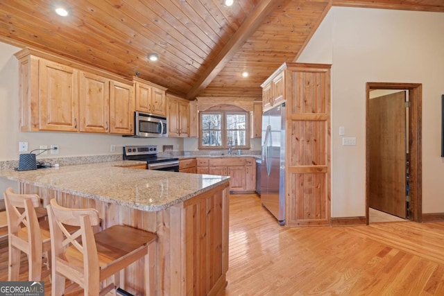 kitchen with vaulted ceiling with beams, light brown cabinets, a peninsula, appliances with stainless steel finishes, and light wood-type flooring