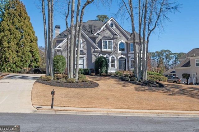 view of front of house with driveway and a chimney