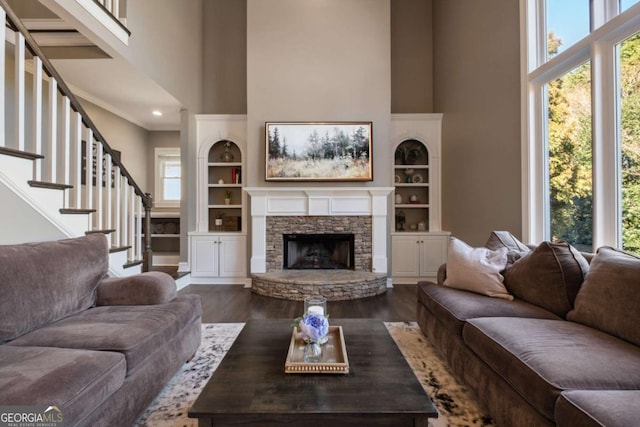 living room featuring a high ceiling, wood finished floors, and a healthy amount of sunlight