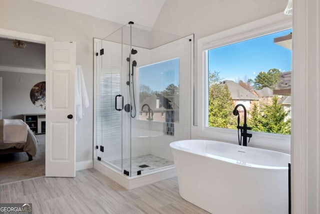 ensuite bathroom with lofted ceiling, ensuite bath, a soaking tub, and a shower stall