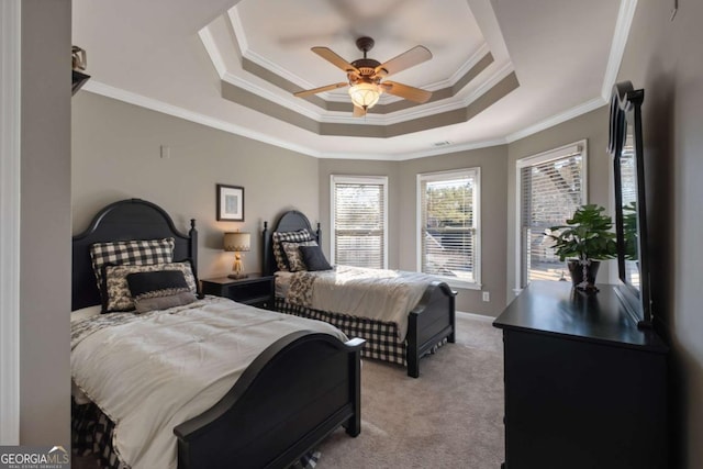 bedroom featuring a tray ceiling, ornamental molding, light carpet, ceiling fan, and baseboards