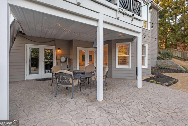 view of patio / terrace featuring a balcony, outdoor dining space, fence, and french doors