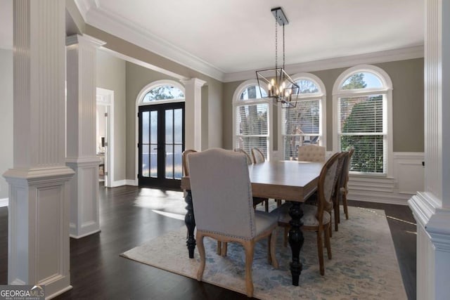 dining space with crown molding, a healthy amount of sunlight, and ornate columns