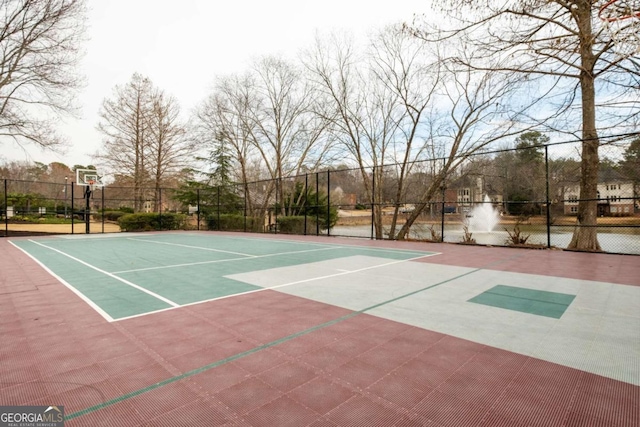 view of tennis court featuring community basketball court and fence